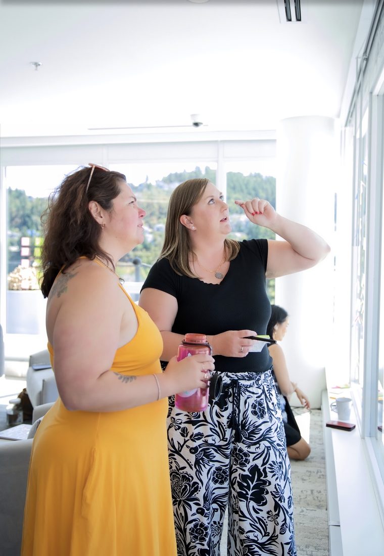 Crystal and a writer plotting a book on a wall of Post-it notes at a Createcation