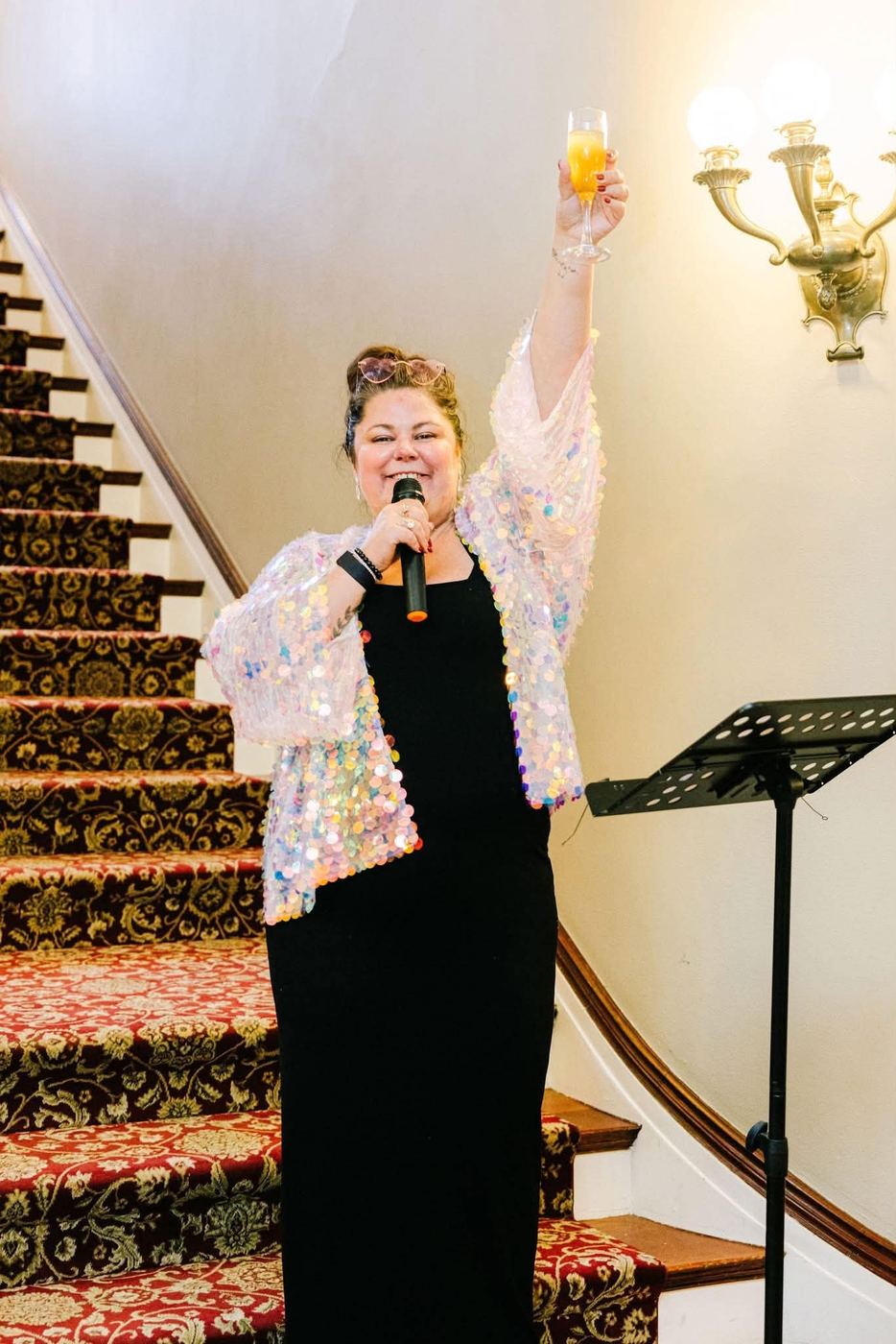 Crystal Adair-Benning hosting Failure Ball in Colorado with a microphone in hand