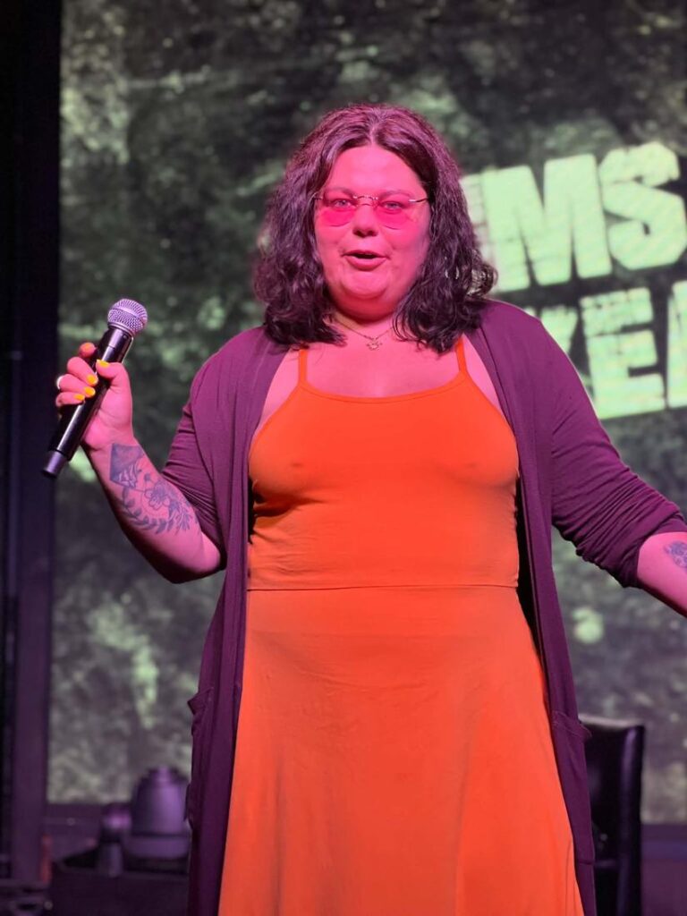 Crystal Adair-Benning speaking on stage holding a microphone