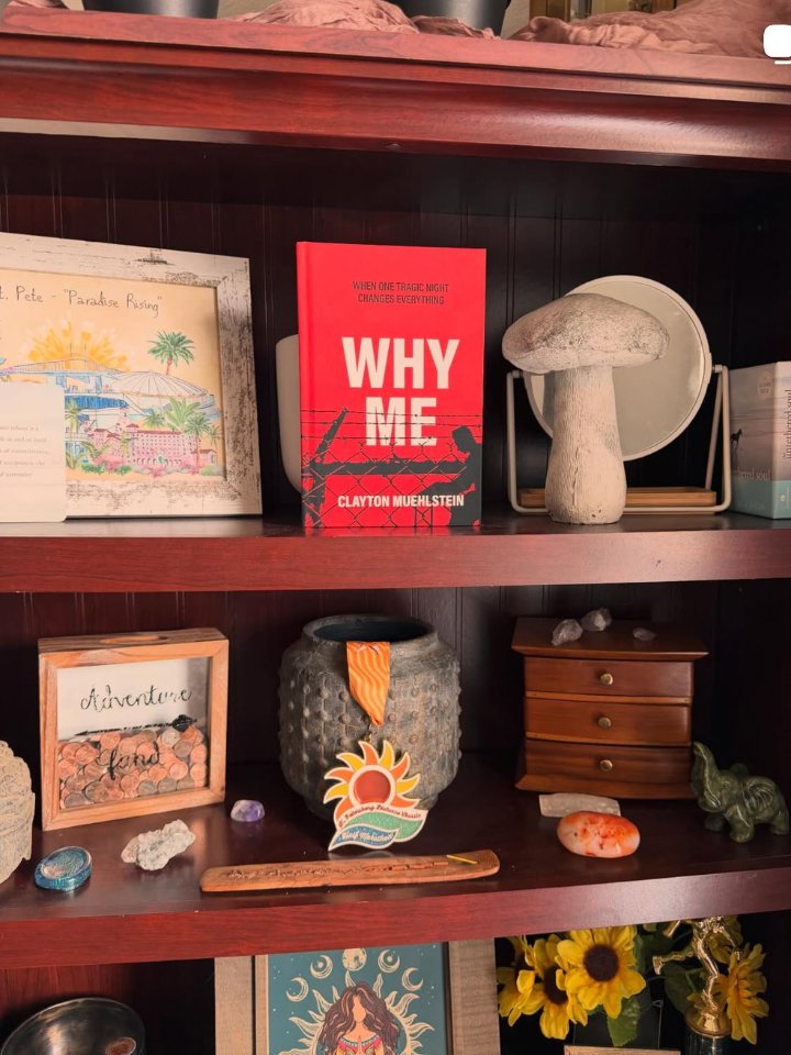 Why Me by Clayton Muehlstein displayed on a reader bookshelf