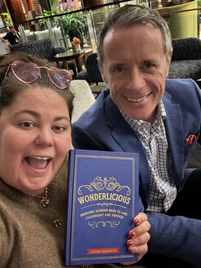 Crystal Adair-Benning with client Peter Merrett holding his published book