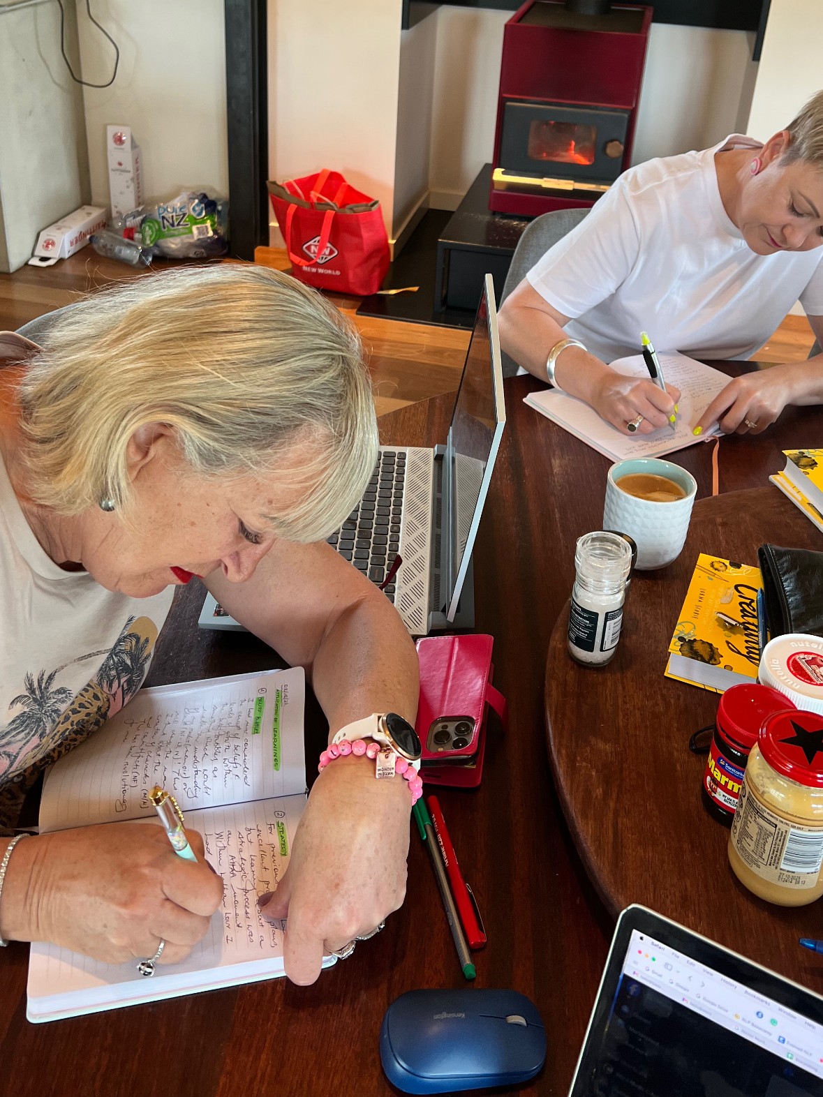A writer working at the table beside a log fire at a Createcation