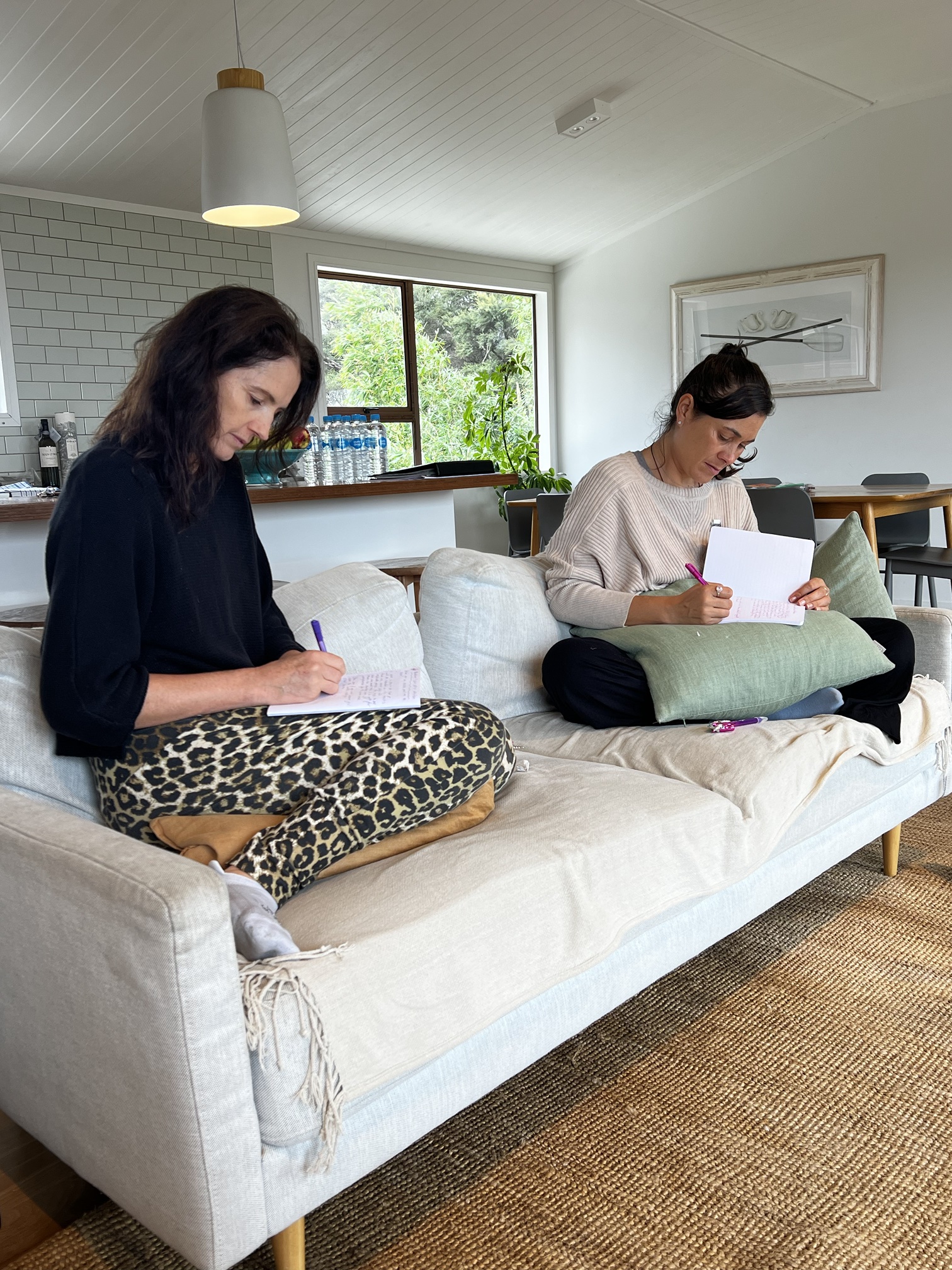 Two writers drafting on a sofa at a Createcation