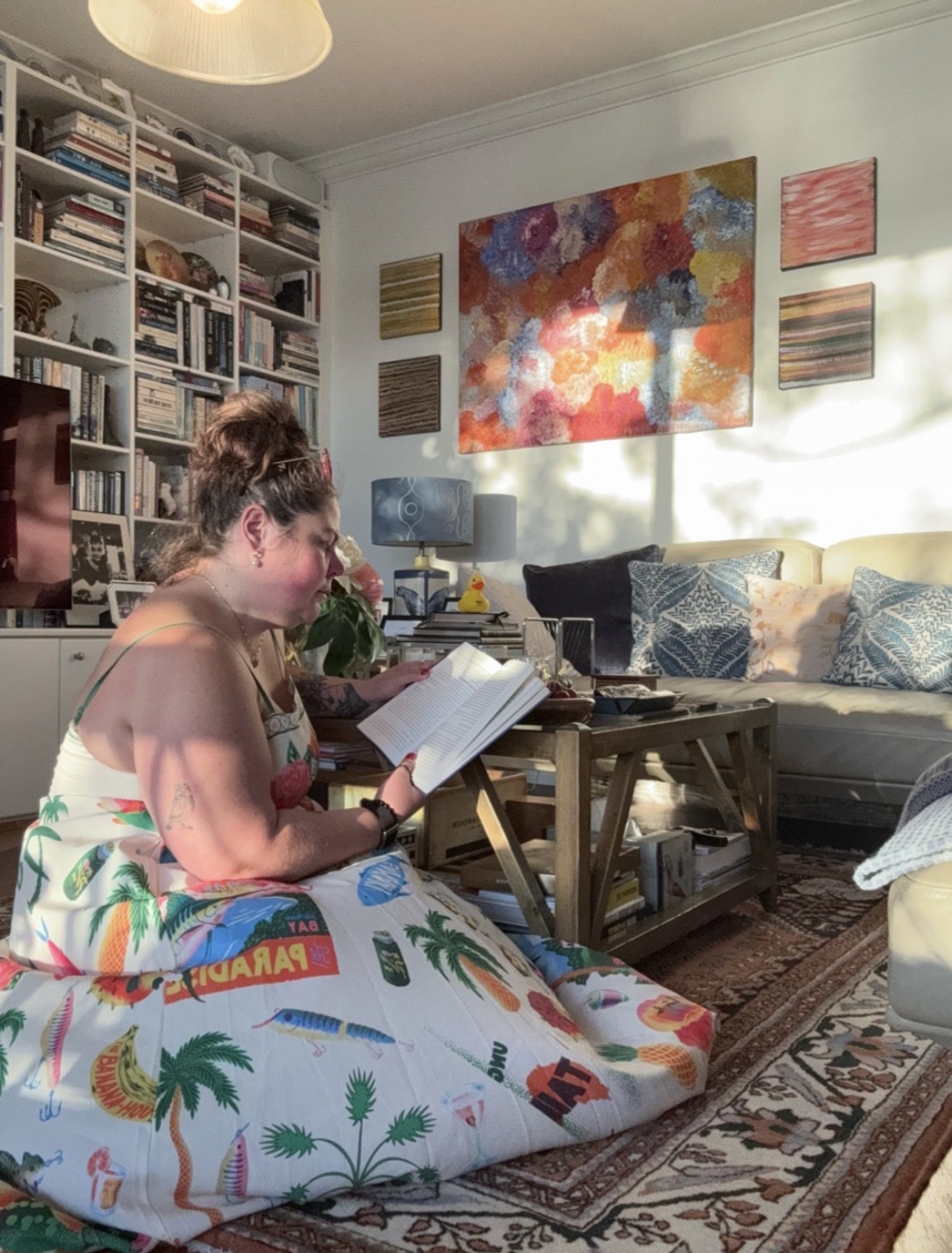 A writer sitting on the floor reading her pages back