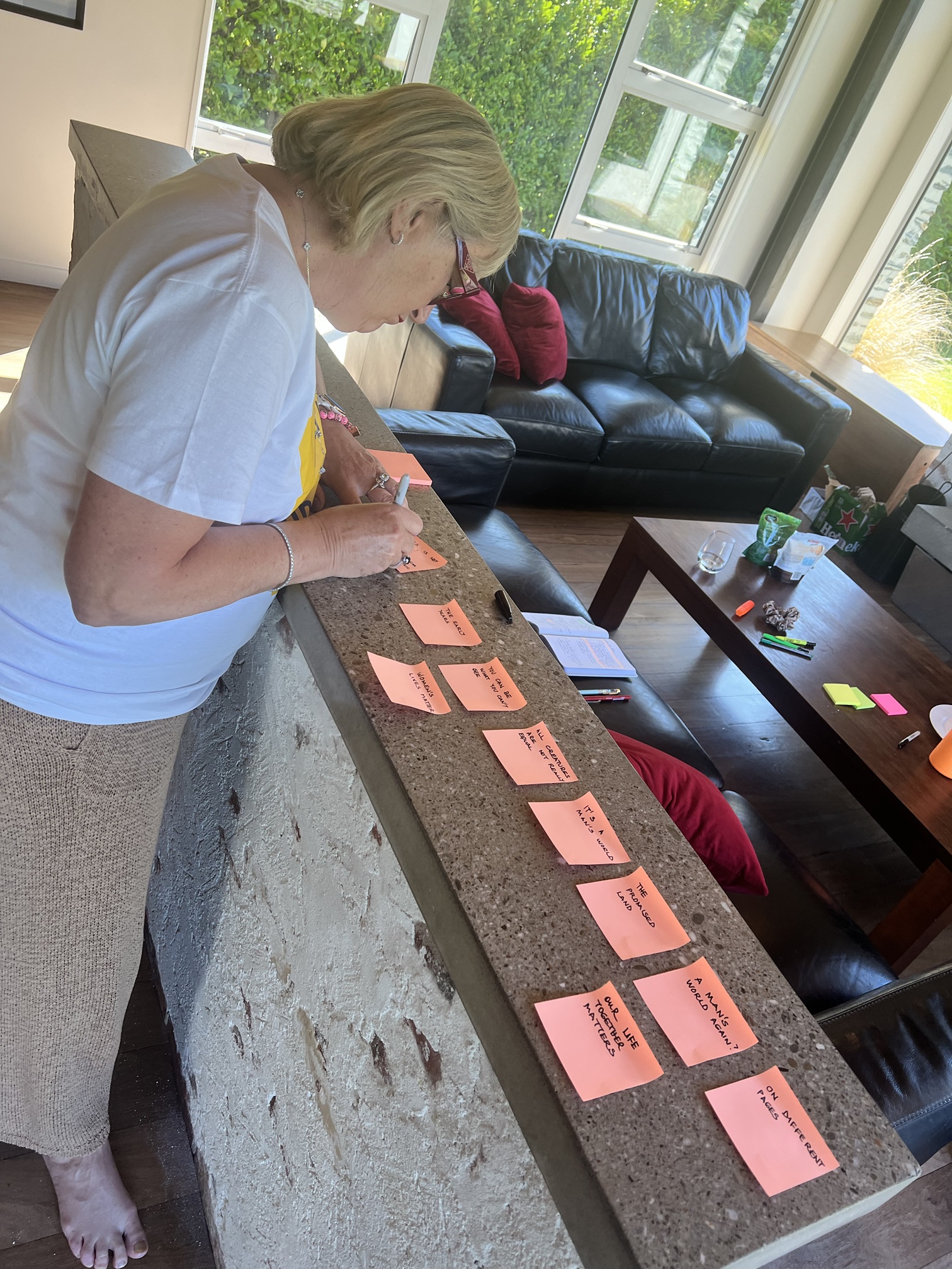 Chapter ideas laid out on orange sticky notes along a kitchen bench