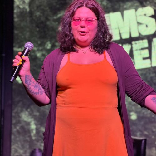 Crystal Adair-Benning speaking on stage holding a microphone